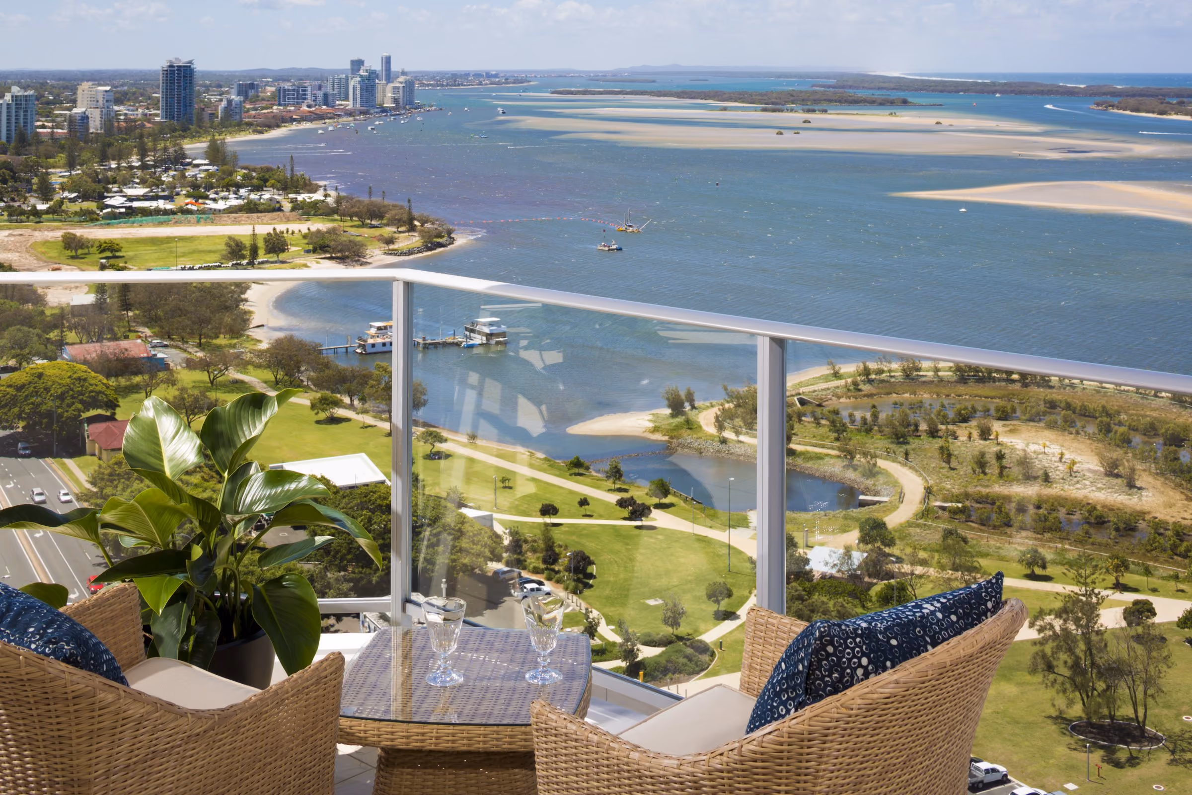 An apartment balcony looking down over the Broadwater Parklands and across the water to the Spit