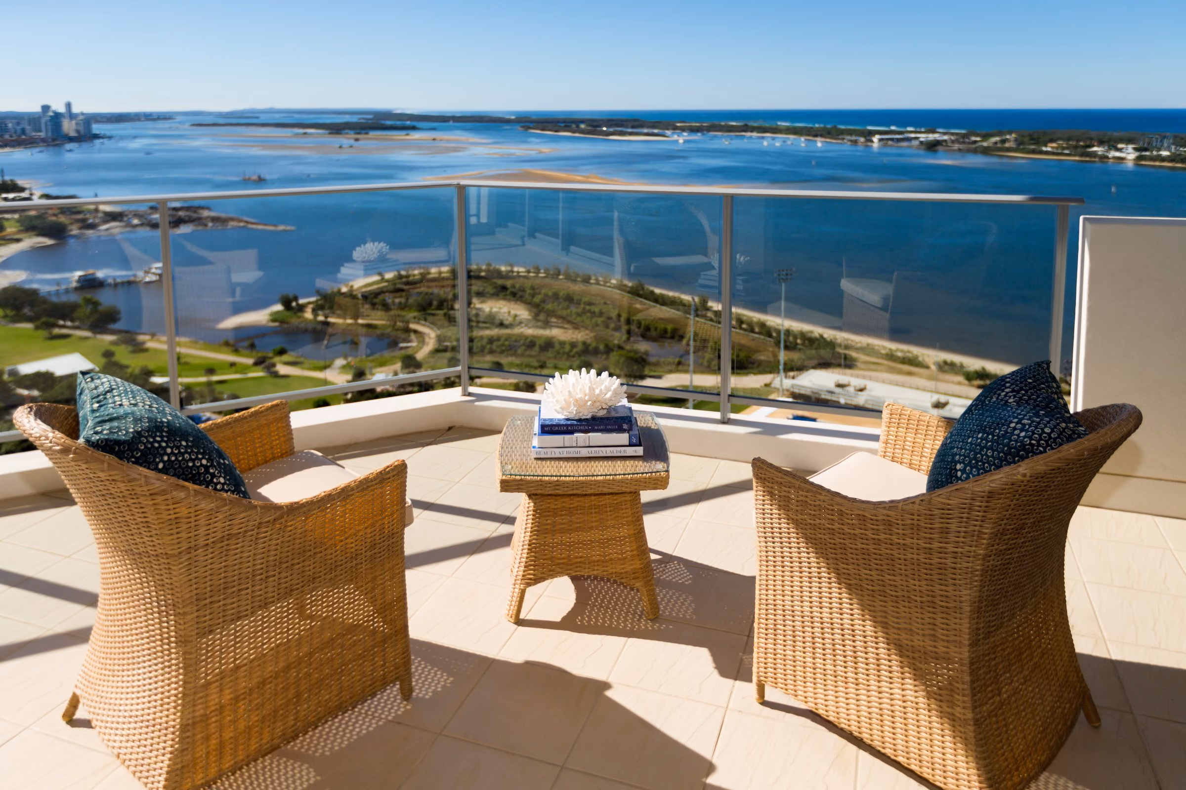 Two wicker chairs on an apartment balcony, looking out over the Broadwater