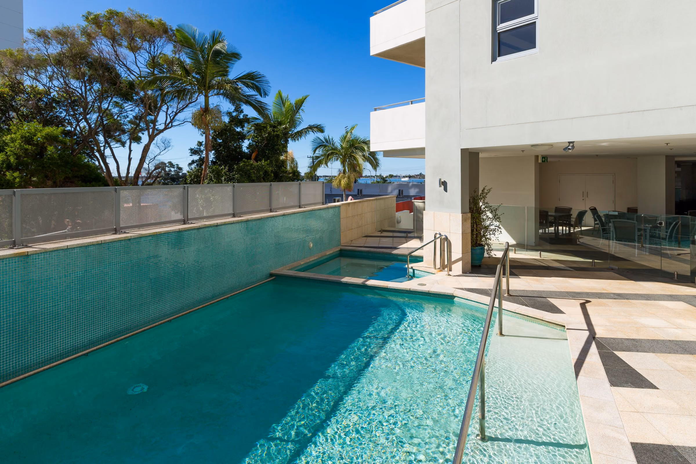 The outdoor pool with palm trees and the tower behind